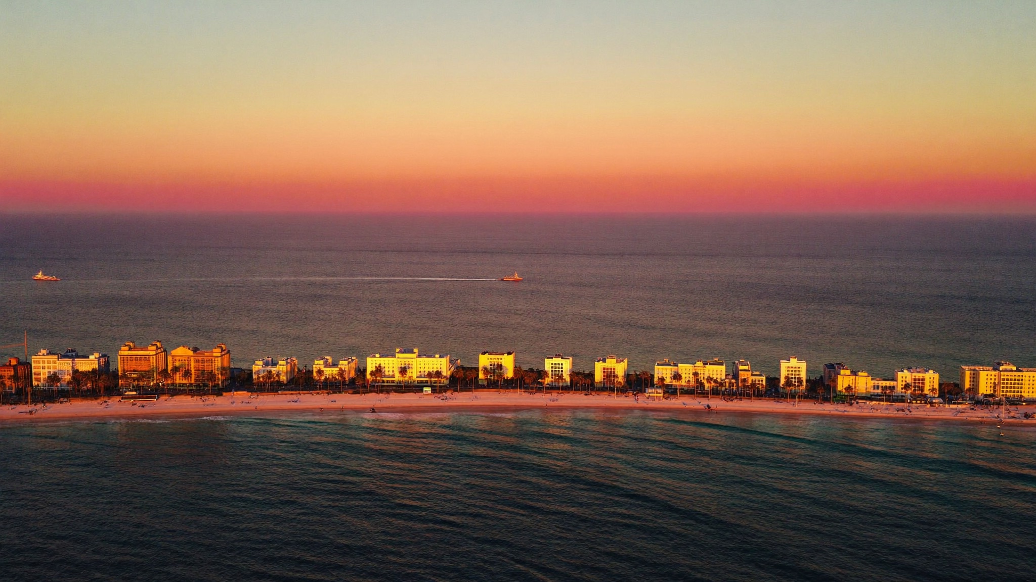 Aerial view of Miami Beach at golden hour — Atlantic ocean in deep blue, art deco buildings along Ocean Drive catching the warm last light
